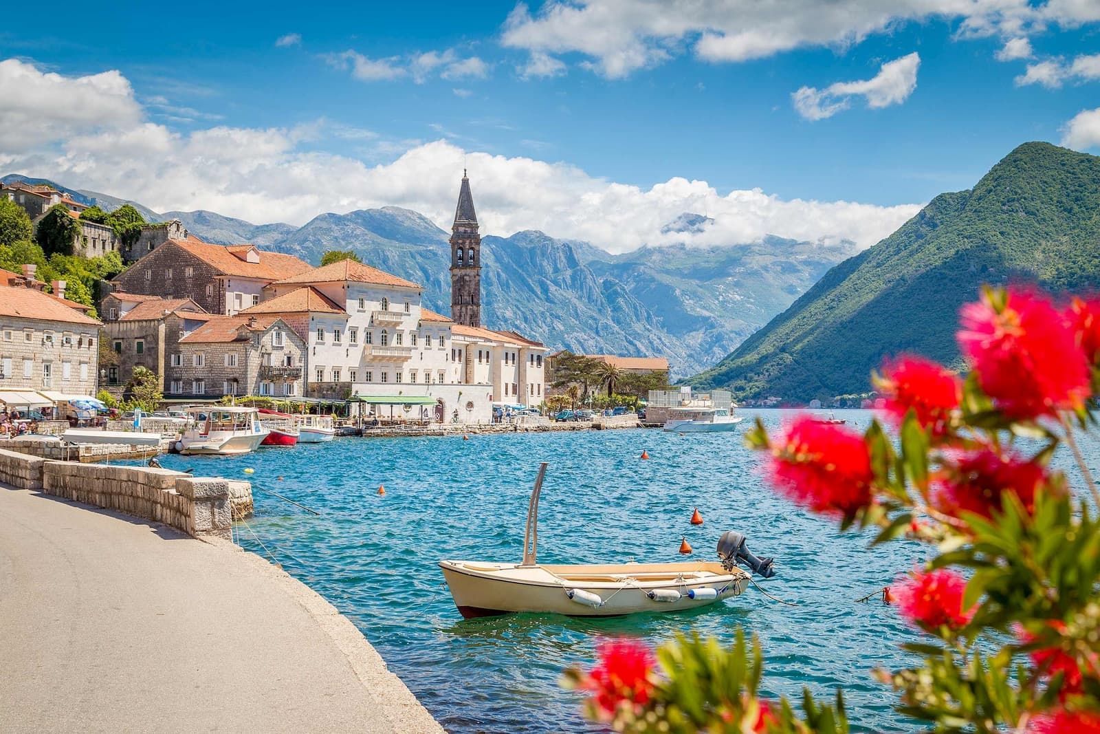 Scenic view of Perast in Kotor Bay with houses, church bell tower and moored boat