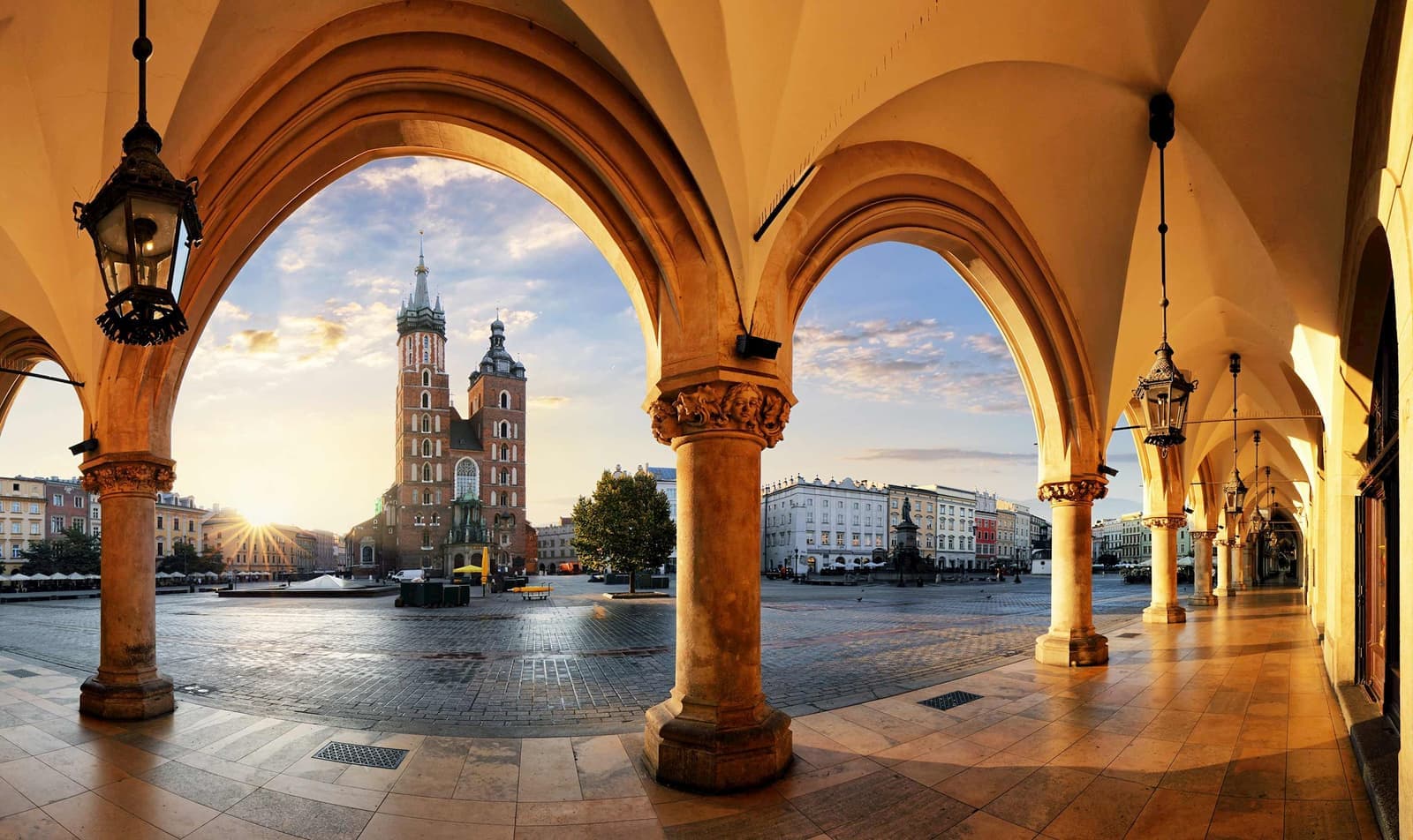 St. Mary’s Basilica framed by Cloth Hall arches at sunrise in Kraków, Poland