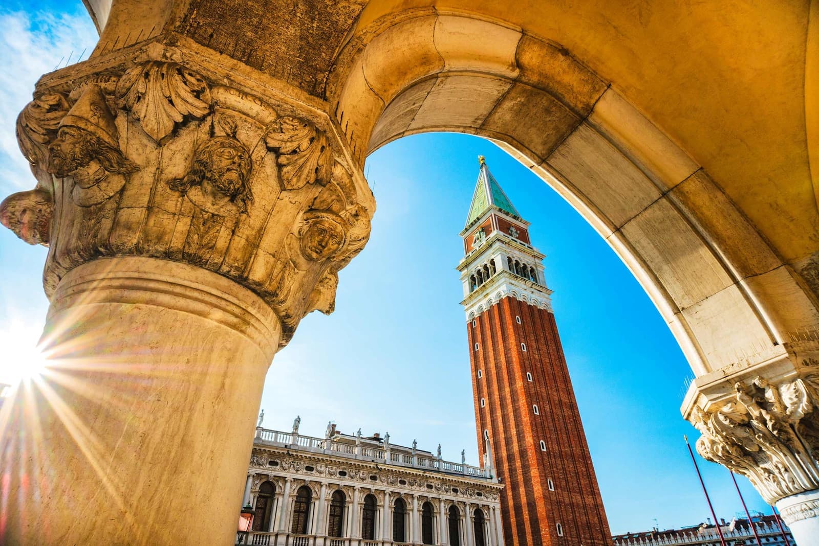 View of St. Mark’s Campanile in Venice framed by stone arch in Venice, Italy