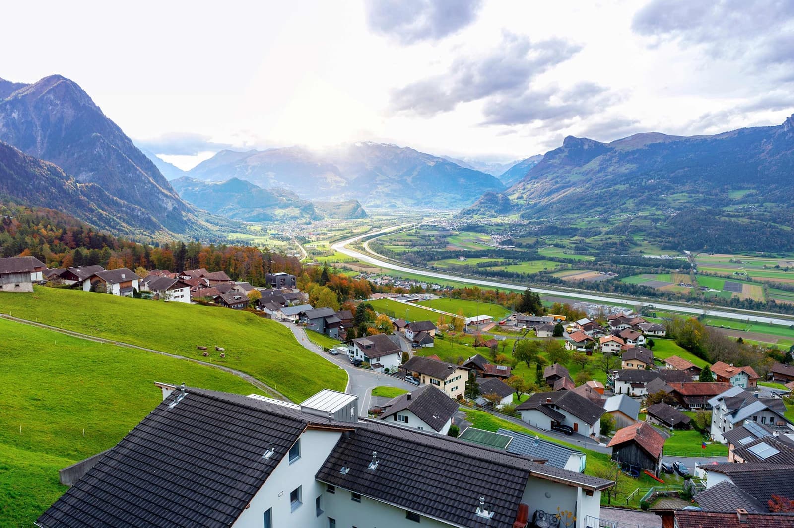 Aerial view of Triesenberg village in Liechtenstein with alpine houses, meadows and River Rhine