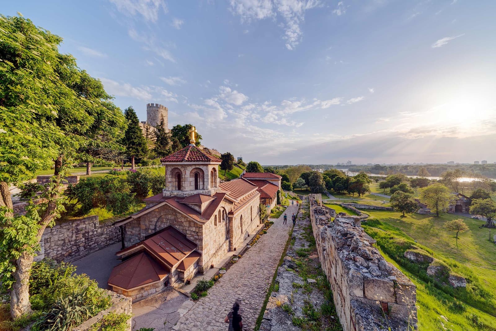 Church of Saint Petka inside Belgrade Fortress with stone walls and greenery at sunset