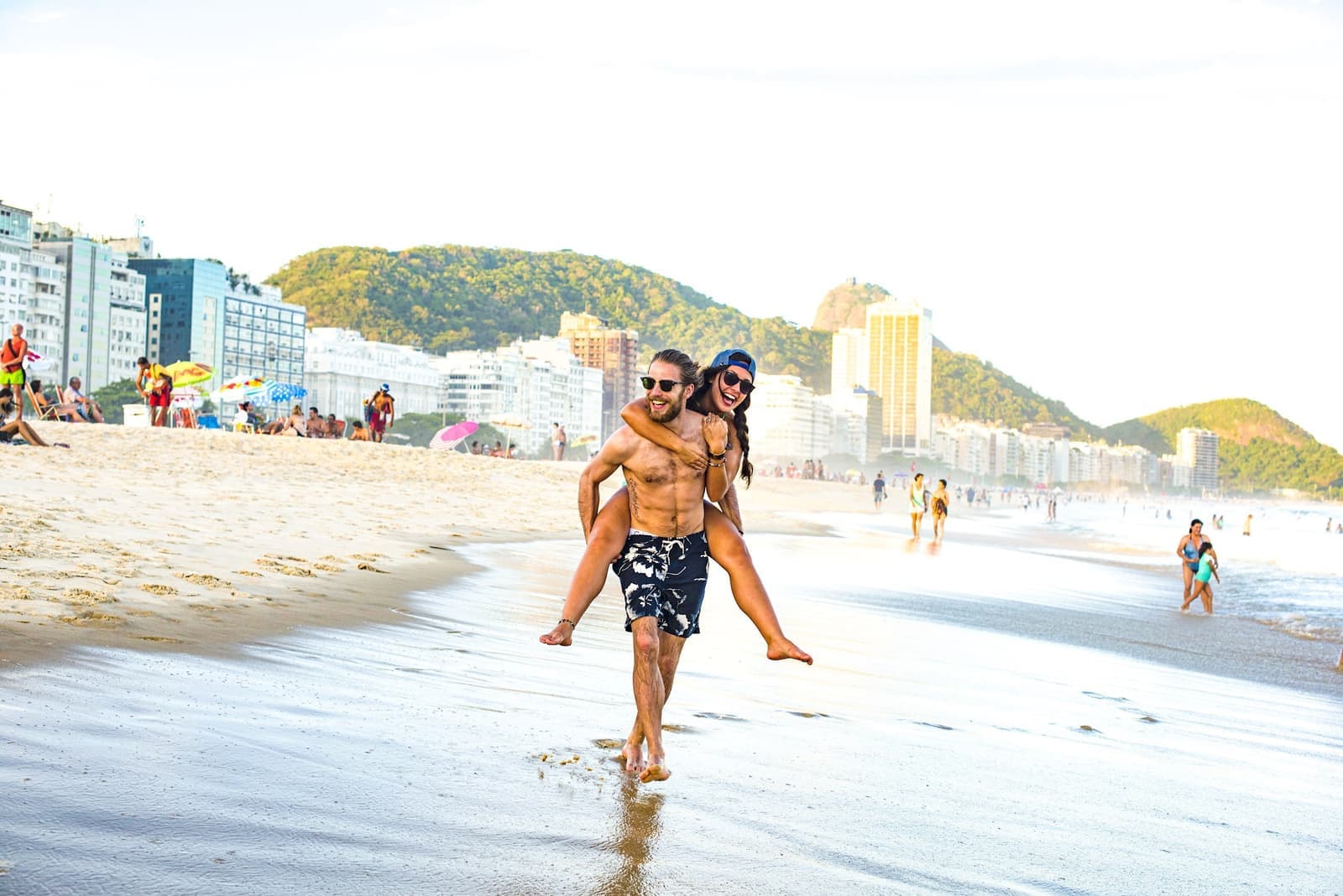 Traveller getting a piggyback on Copacabana Beach in Rio de Janeiro, Brazil