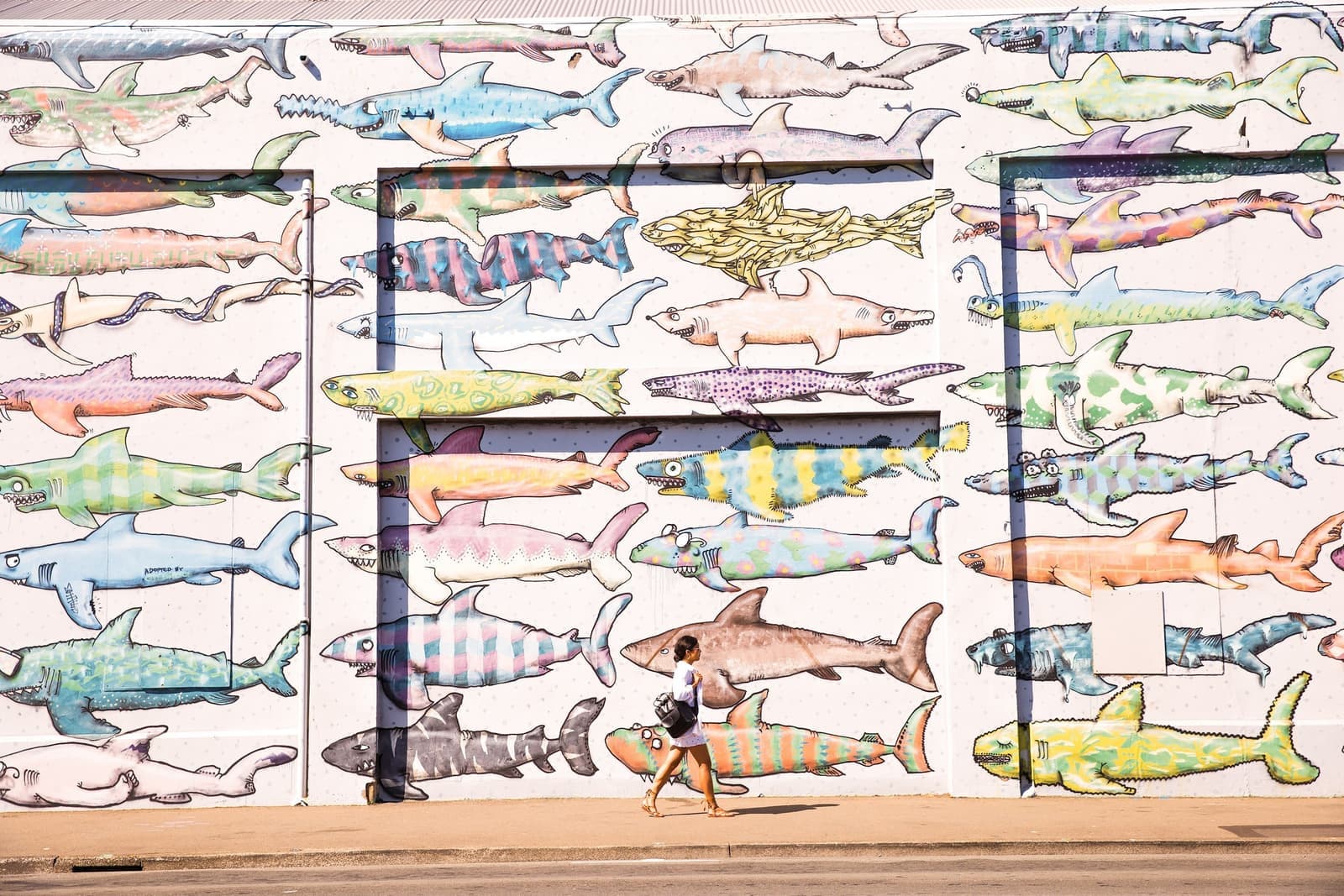 Travellers walking past street art in Wellington, New Zealand