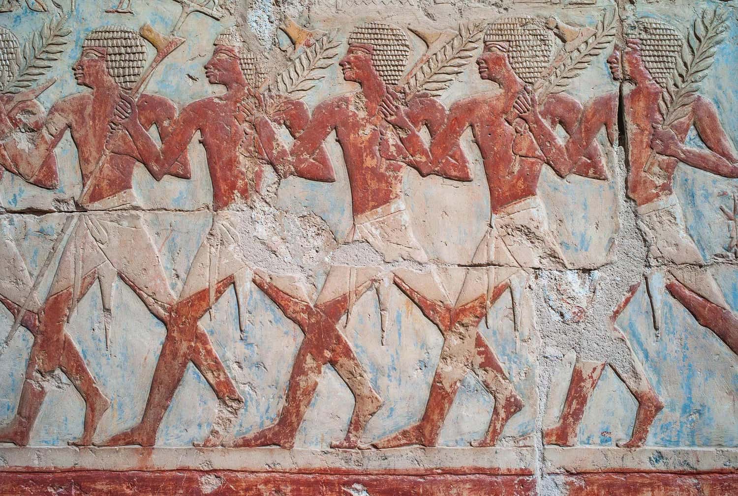 Historic stone carving of figures in traditional attire in Cairo, Egypt