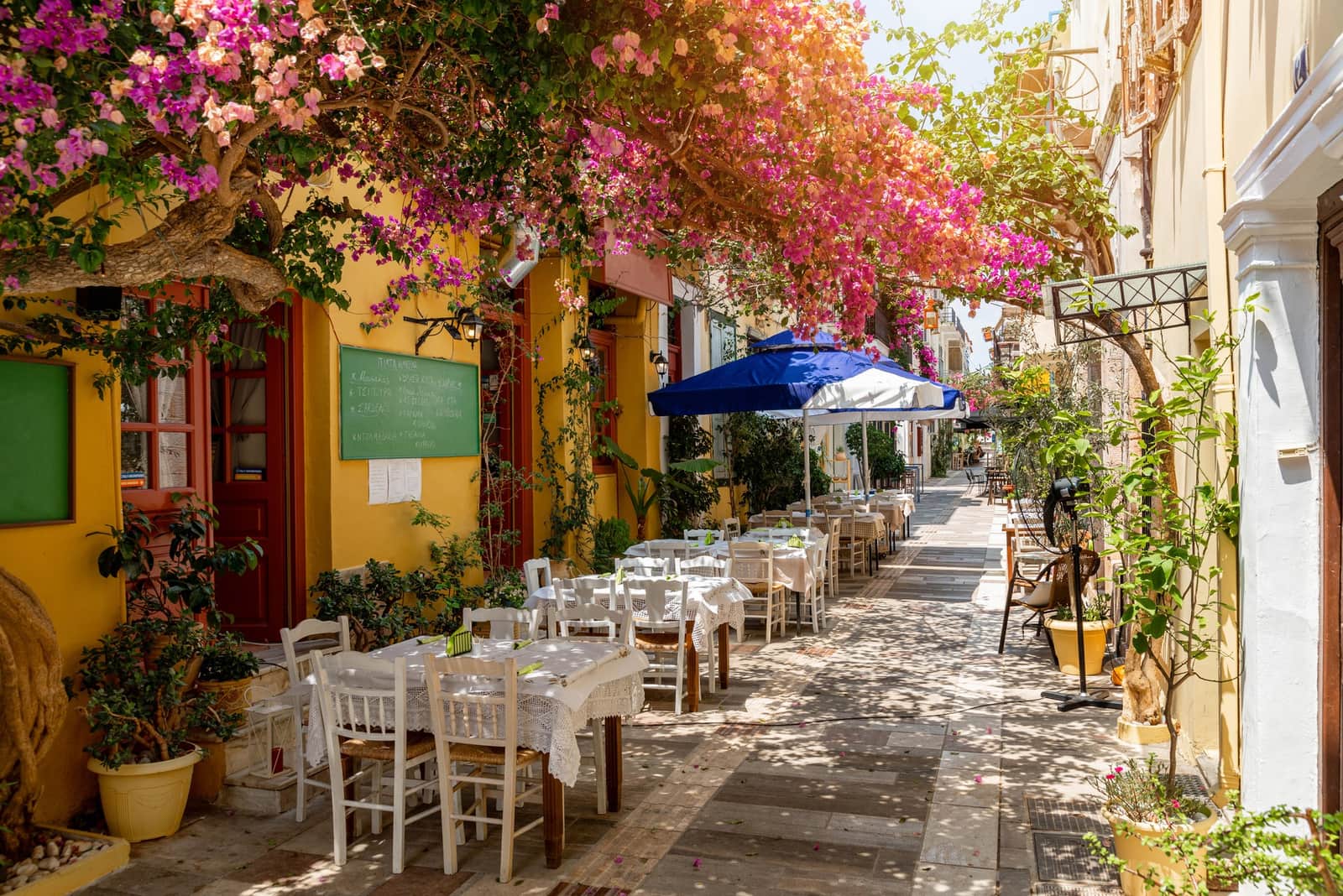 Restaurant in flower covered street in the beautiful Greek town of Nafplio, Greece.
