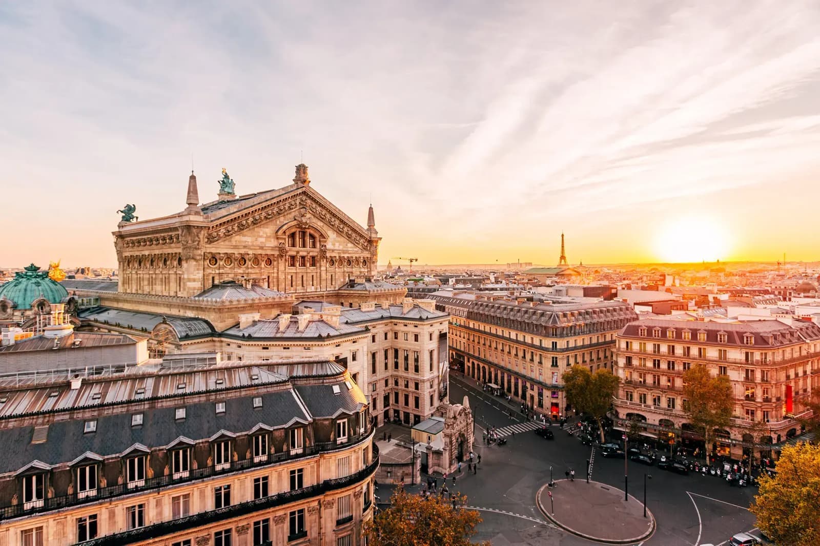 The Palais Garnier opera house and Eiffel Tower in Paris, France, at sunset.