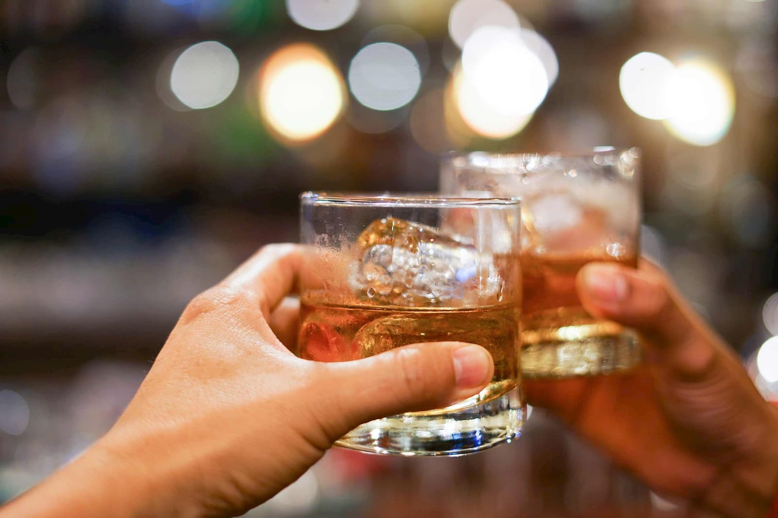 Two people toasting glasses of Scottish whiskey