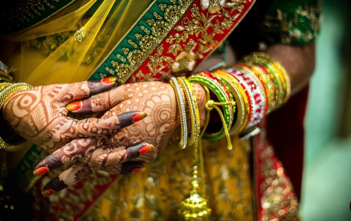 Close-up of hands with bridal mehndi and colourful bangles
