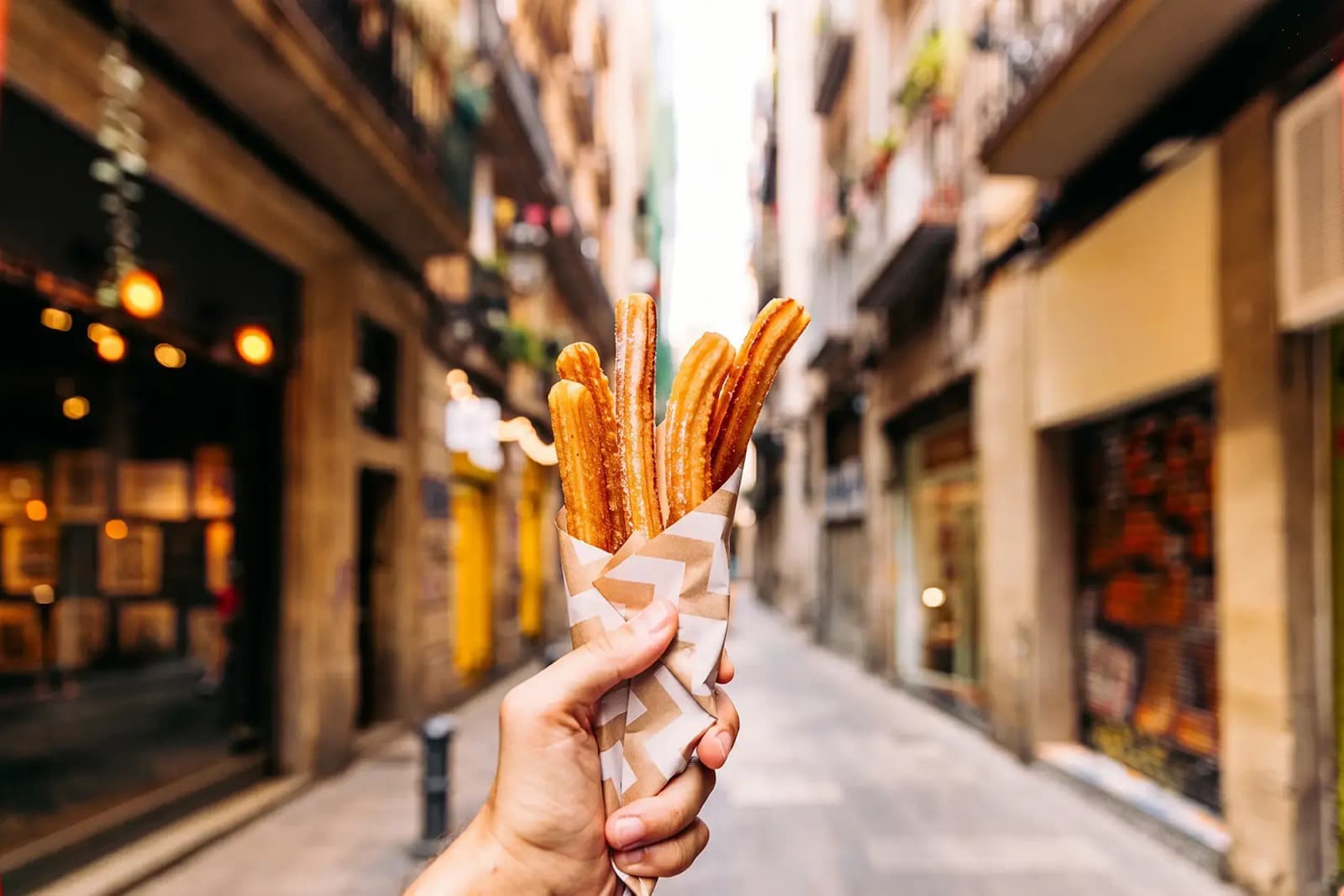 Day Hero Eating churros on the street in Gothic Quarter, Madrid, Spain