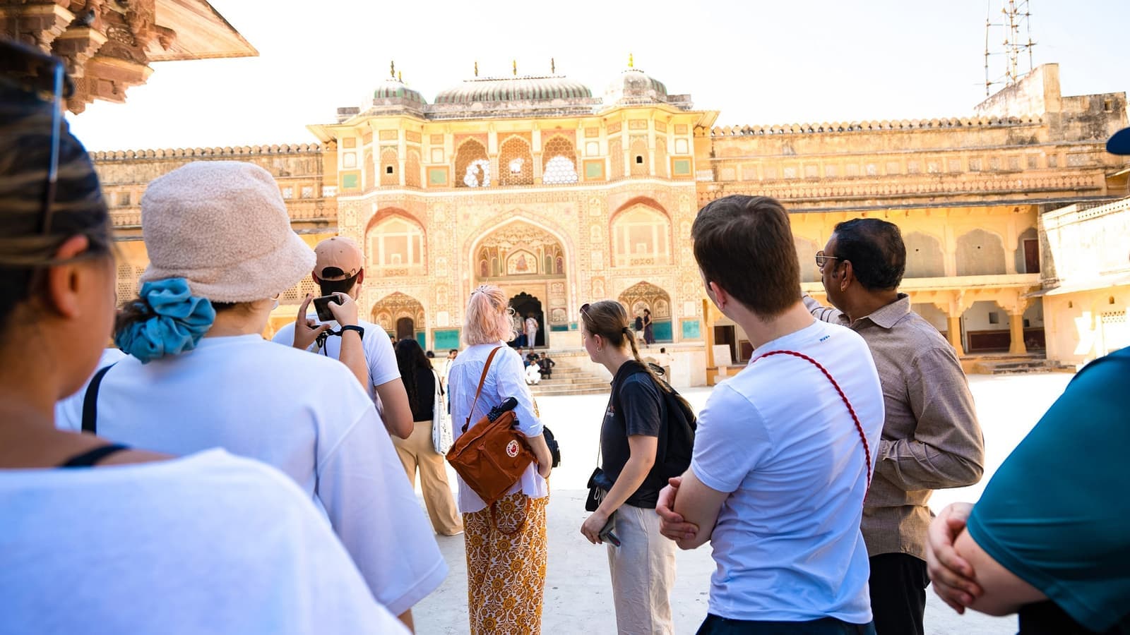 Group of travellers looking away from the camera towards the Amer Fort in Jaipur, India