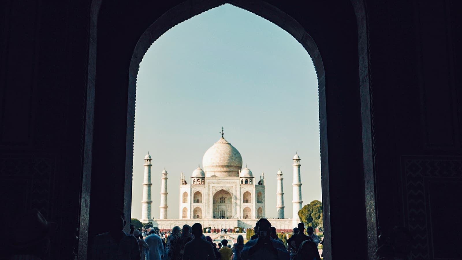 The Taj Mahal framed by a dark, arched stone doorway, Agra, India