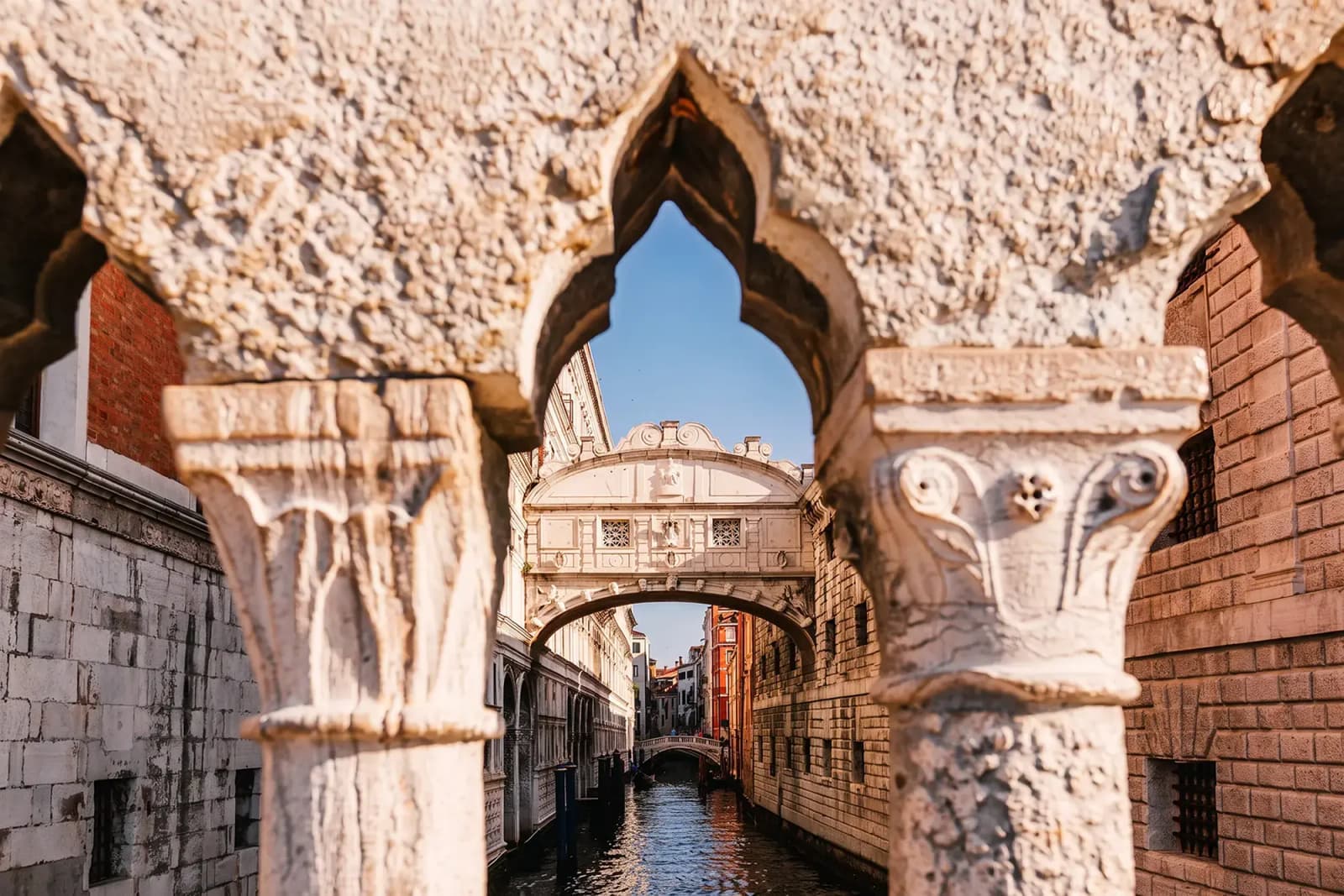 The Bridge of Sighs in Venice, Italy, viewed through stone arches.