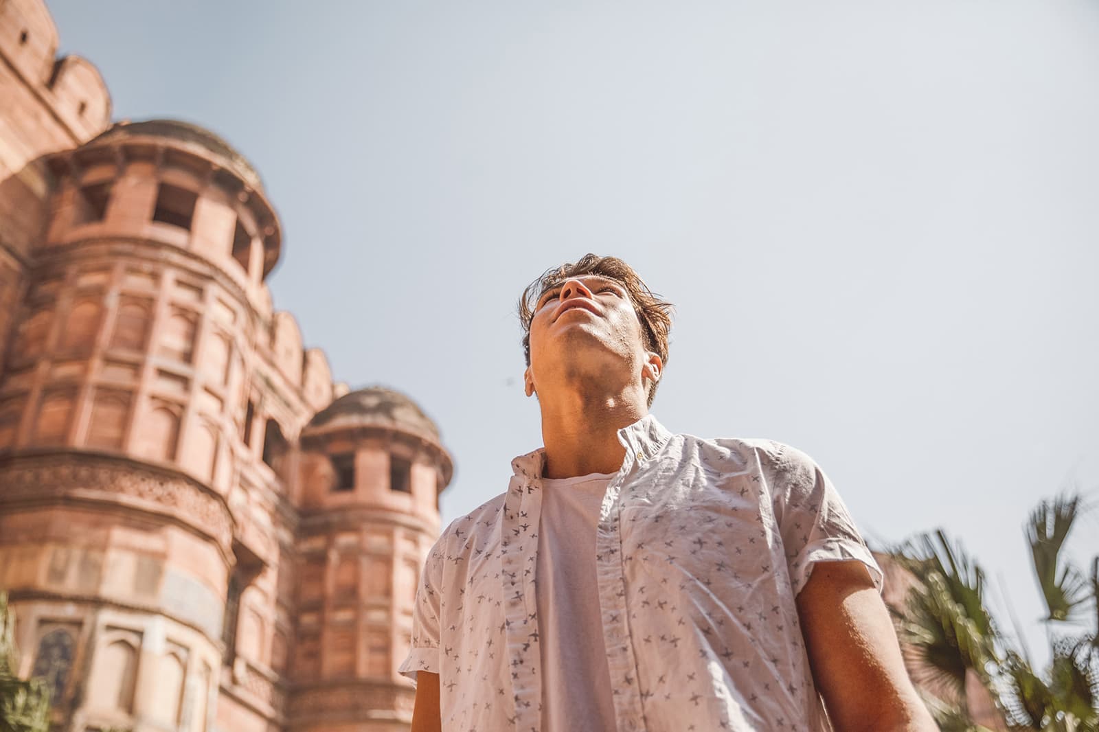 Man looks up toward the red sandstone Agra Fort, Agra, India