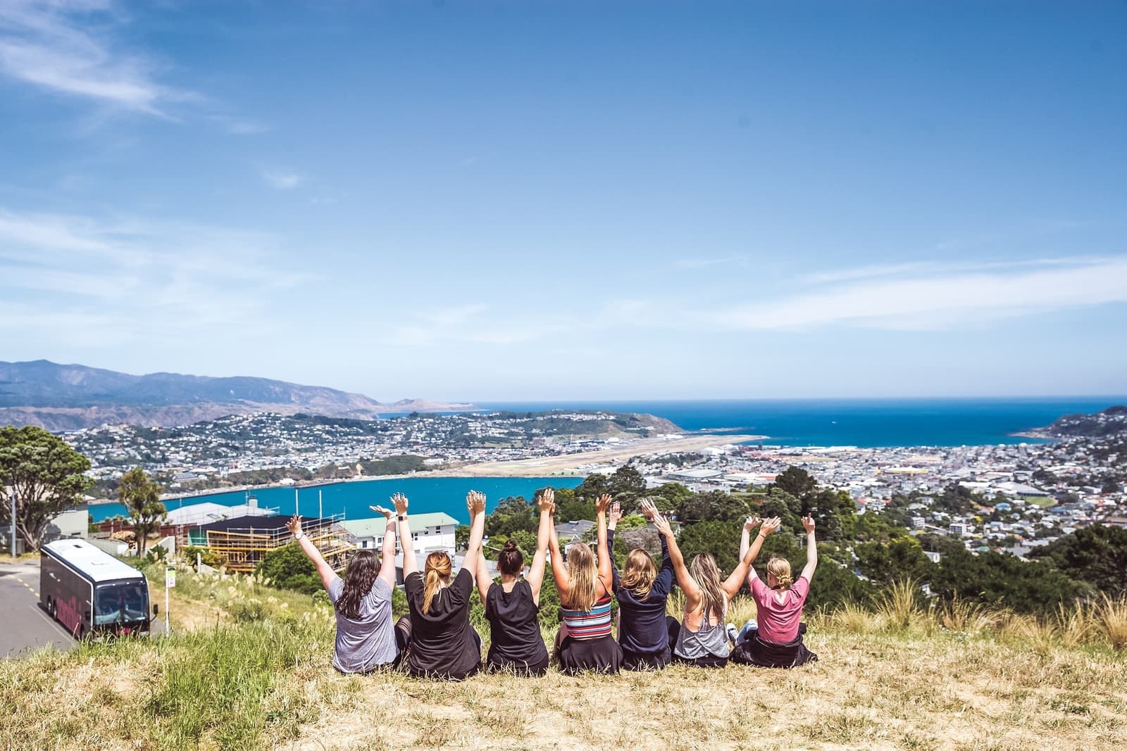 Travelers With Arms In The Air Overlooking View, New Zealand