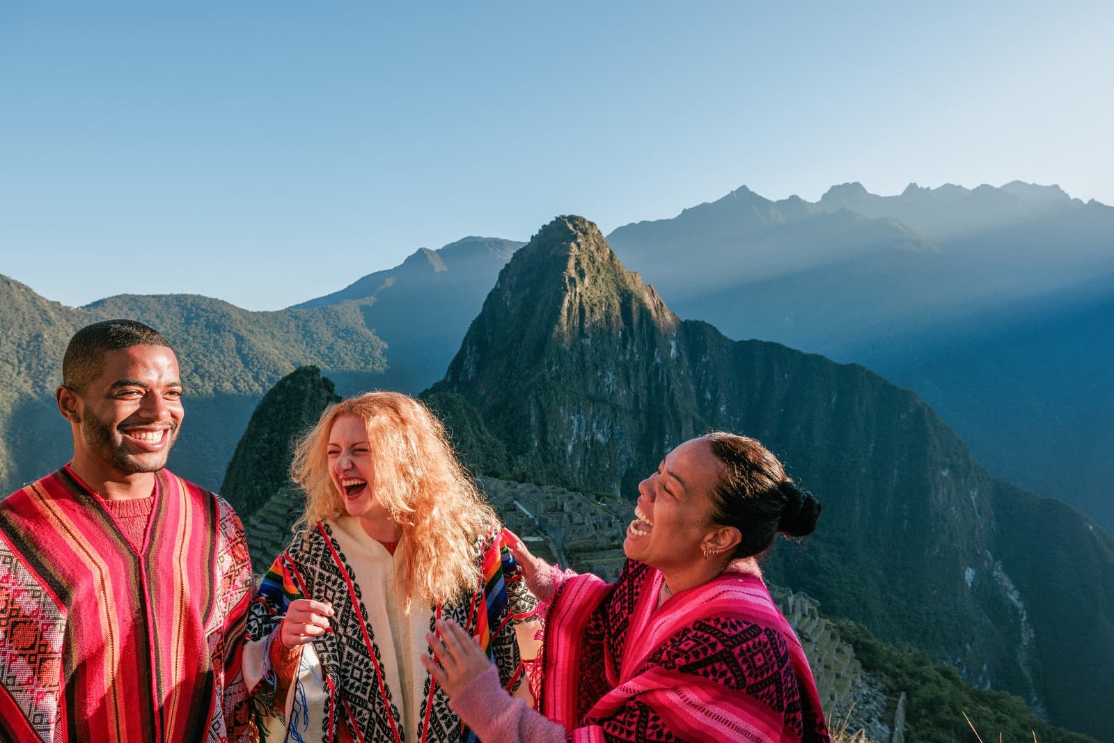 Travellers laughing together with Machu Picchu in the background in Peru