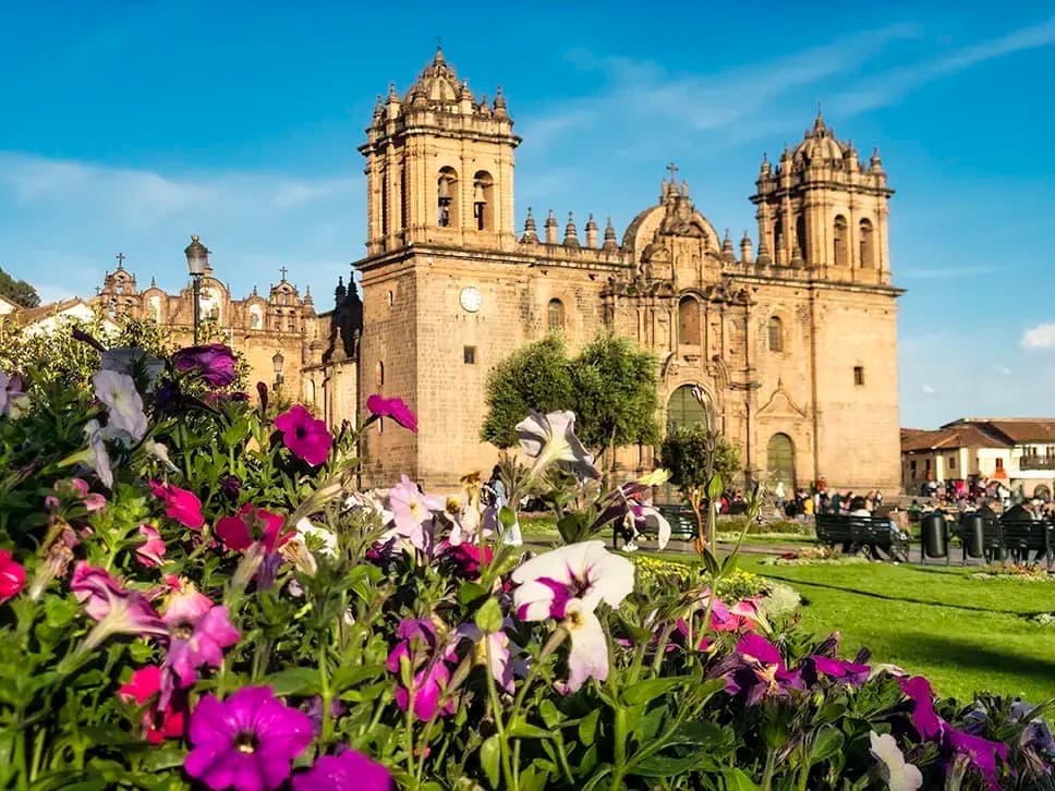 View of cathedral of Plaza de Armas behind blooming flowers, in Cusco, Peru