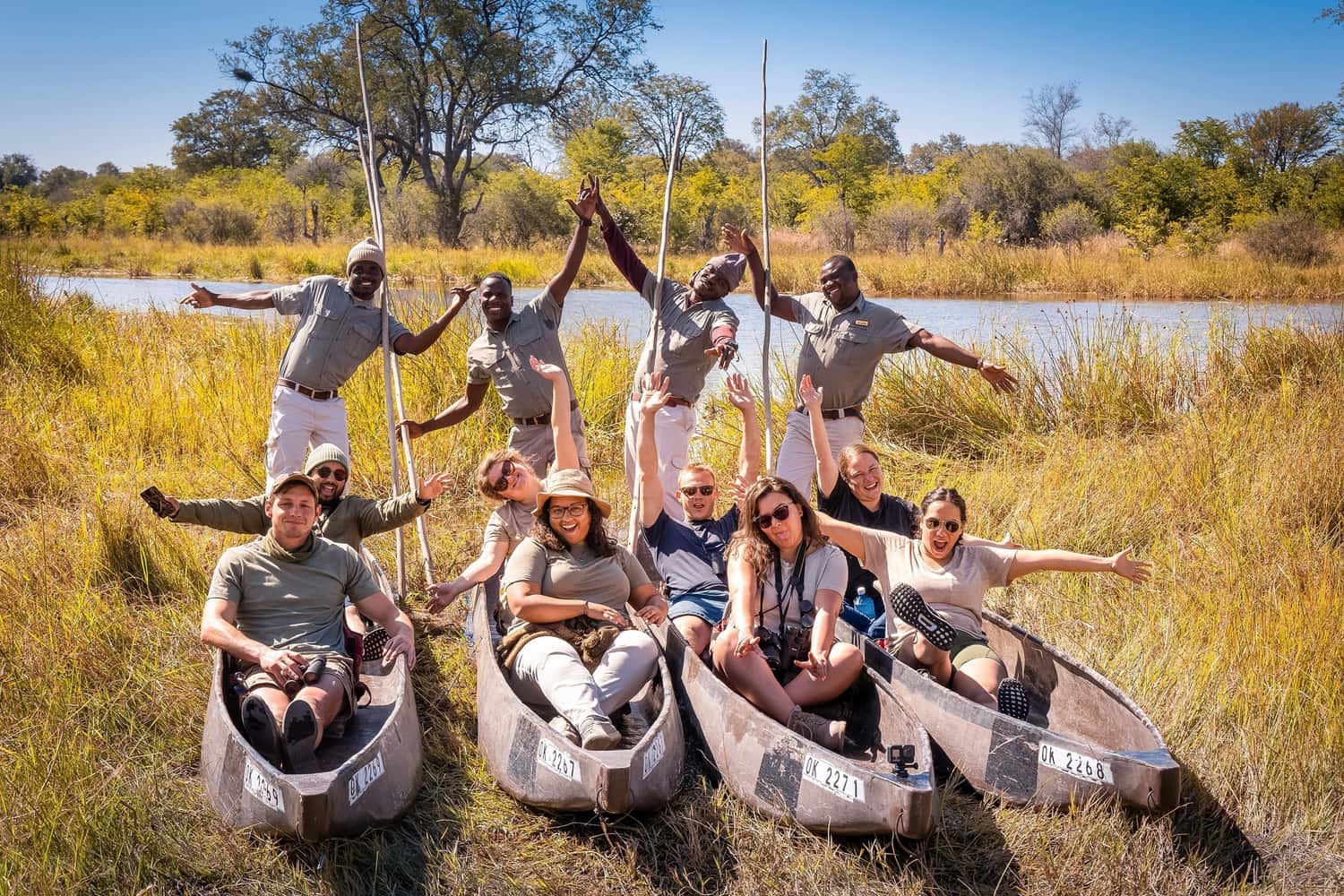 Travellers and guides posing for a fun picture in Mokoro Boats in Okavango Delta, Botswana