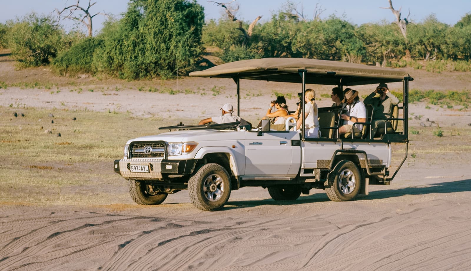 Travellers sat in safari vehicle during a game drive, Chobe, Botswana