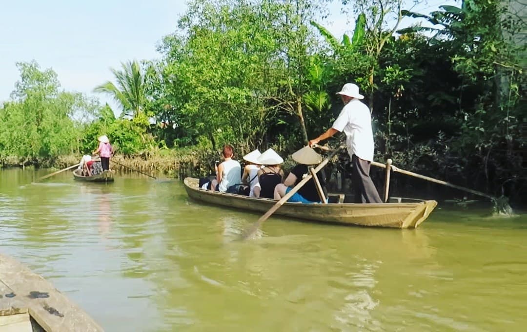 Travellers on a local boat at the Mekong Delta in Vietnam