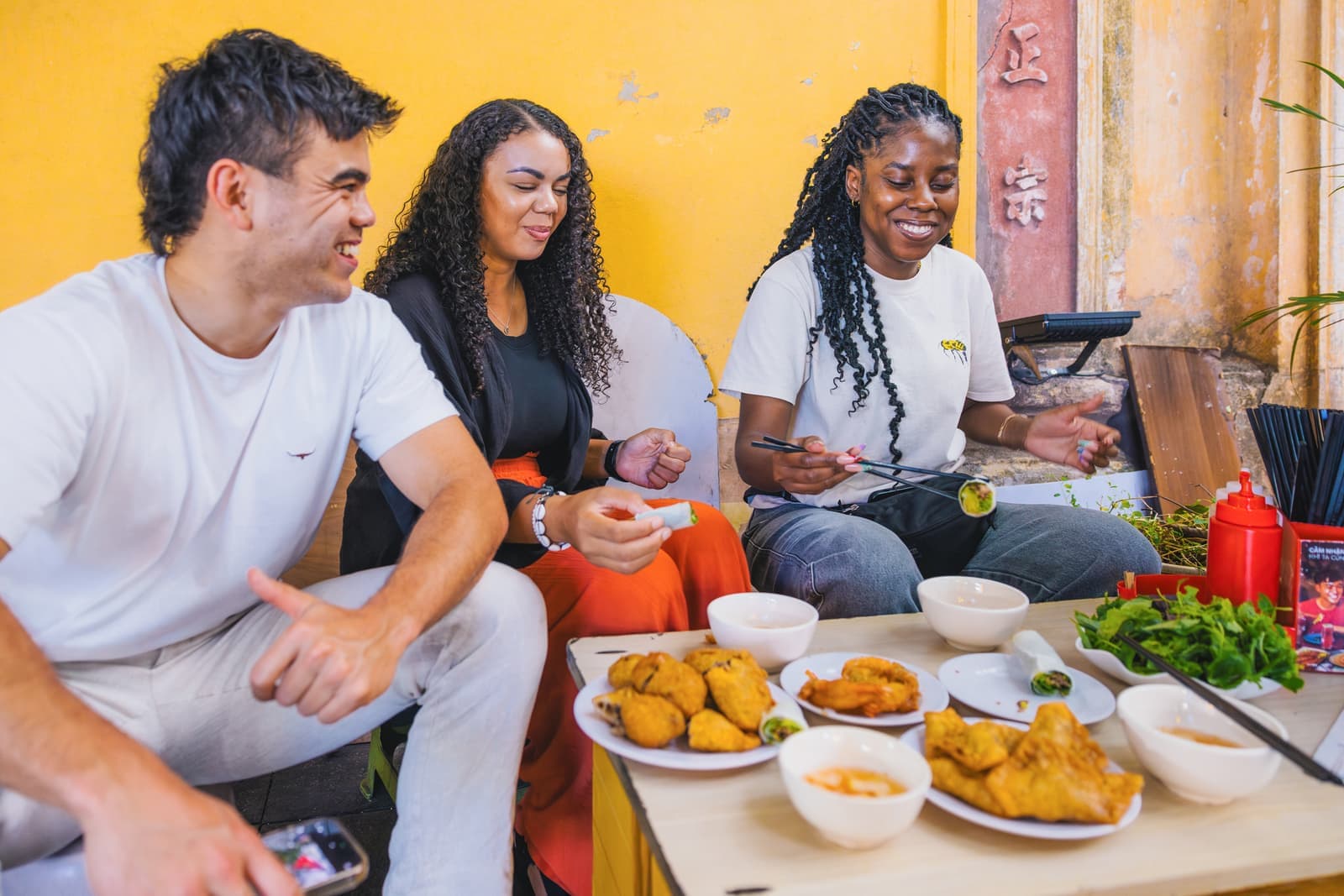 Three travellers trying Vietnamese dishes, Hanoi, Vietnam