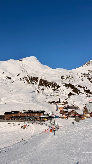 Skiers above a snowbound mountain village